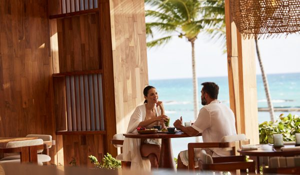 couple dines in open-air restaurant by ocean
