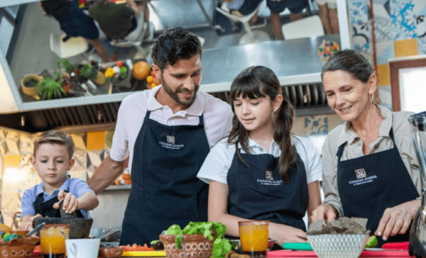 family prepares food at cooking class in mayakoba