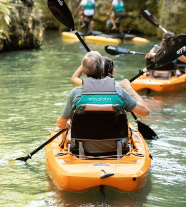 family kayaks through natural canal waterways at mayakoba