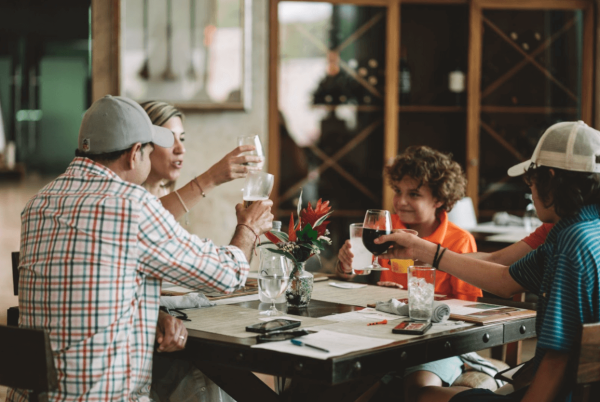 family sheers drinks at tropical dining table at a mayakoba restaurant