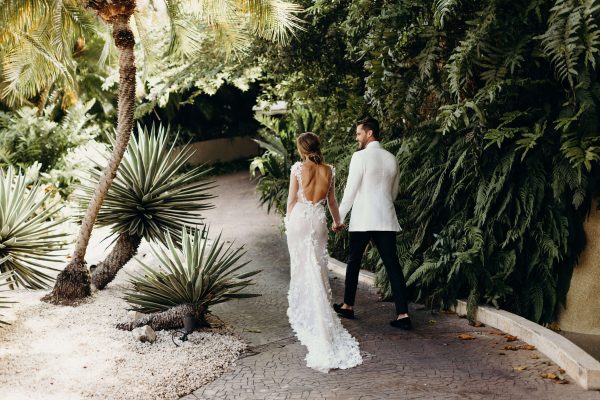 wedding couple walks down path holding hands