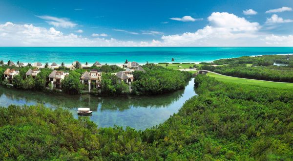 boat sails through canals next to beachfront ocean