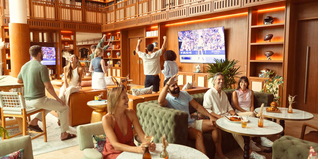 crowd cheers watching sports game on TV at golf clubhouse