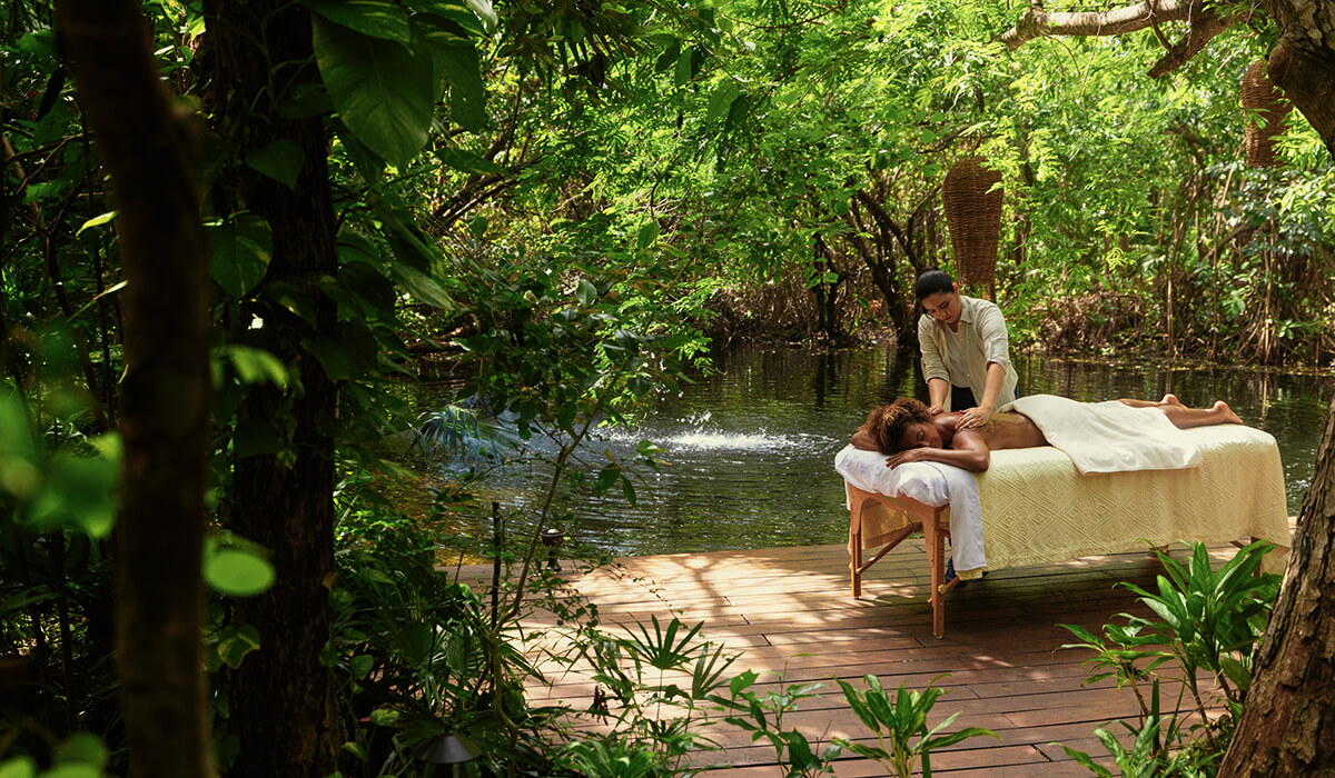 woman enjoys masage by canals outside at mayakoba