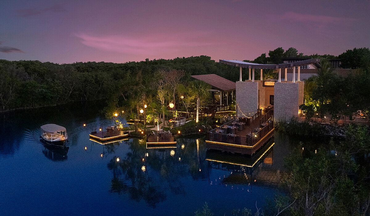 private waterfront restaurant with boat driving by at sunset