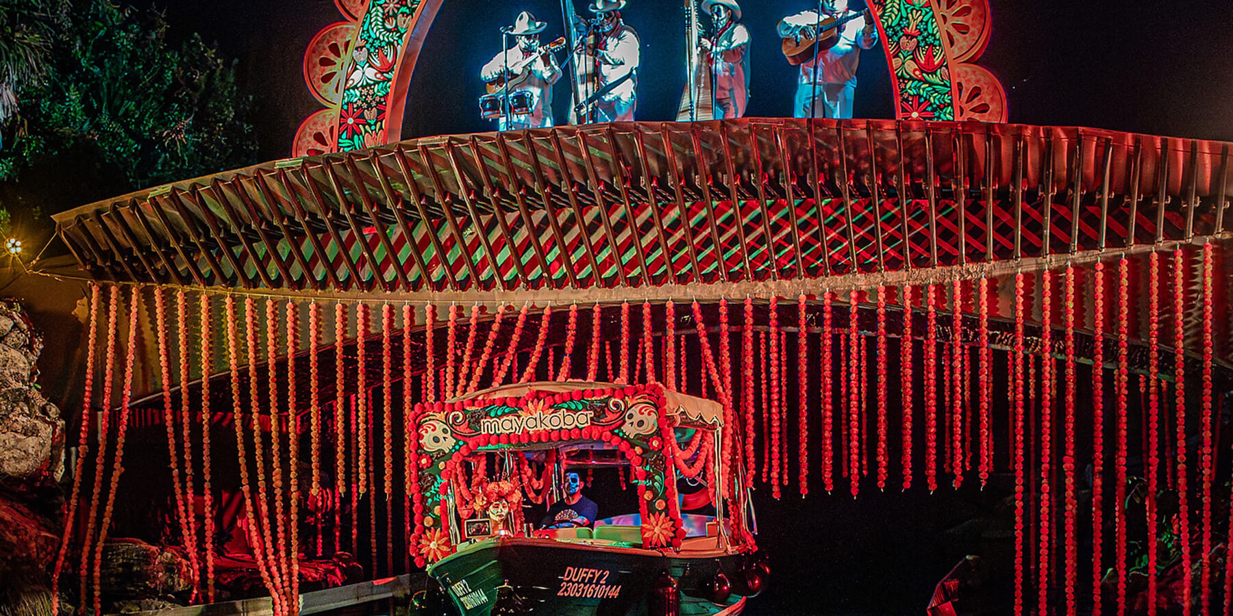 boat passes under bridge with singers on top