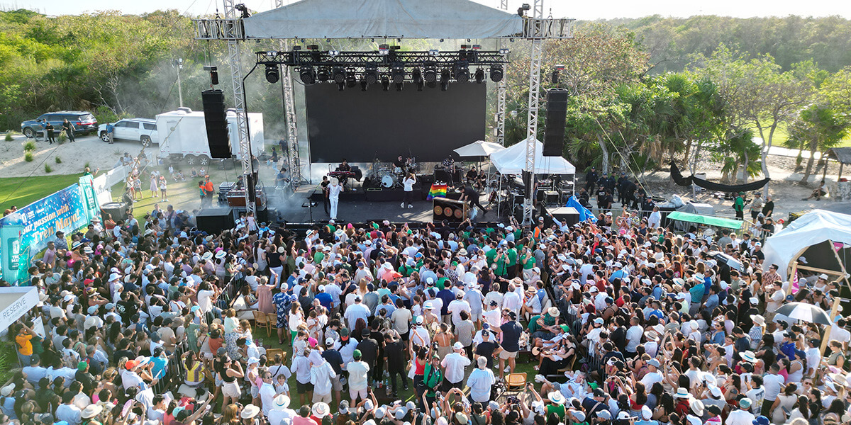 large crowd gathers for outdoor concert in front of stage