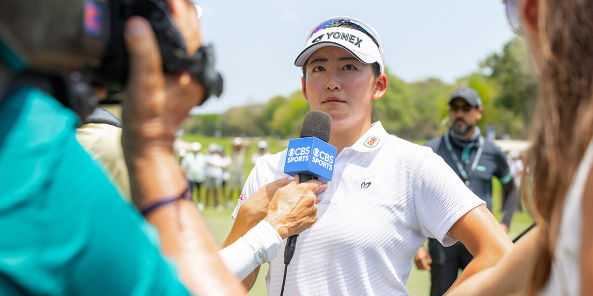 woman golfer interviewed on camera with microphone